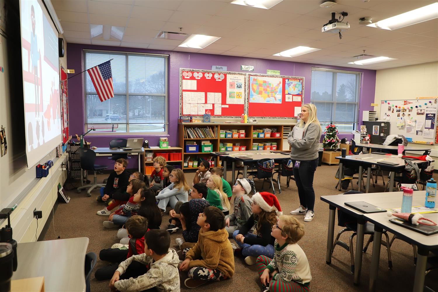 Mrs. Gruntorad leading a lesson on the board with students sitting on the carpet in a group.
